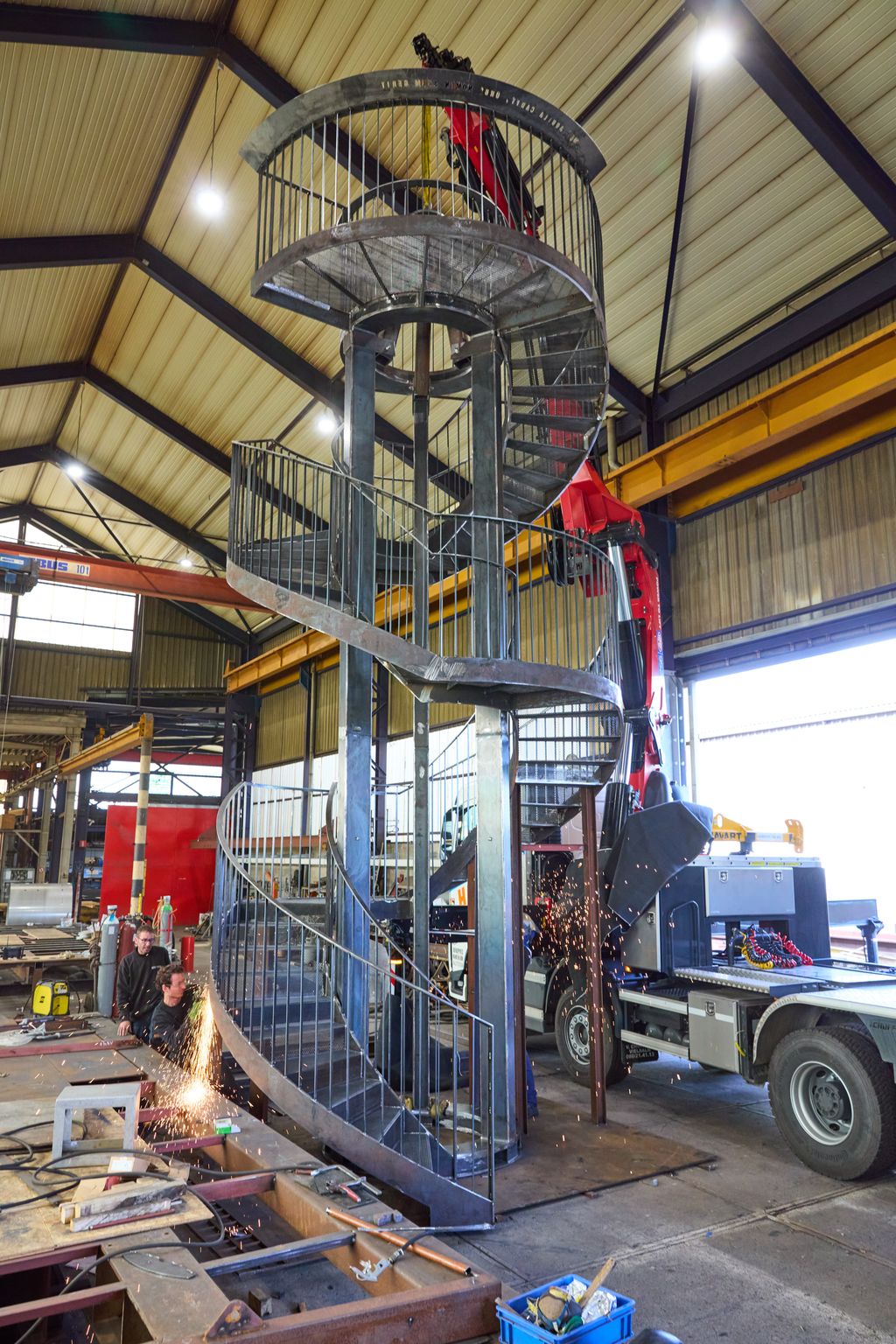 Escalier hélicoïdal en acier Corten en phase d’assemblage en atelier – marches perforées découpées par DELHEZ SA en Belgique